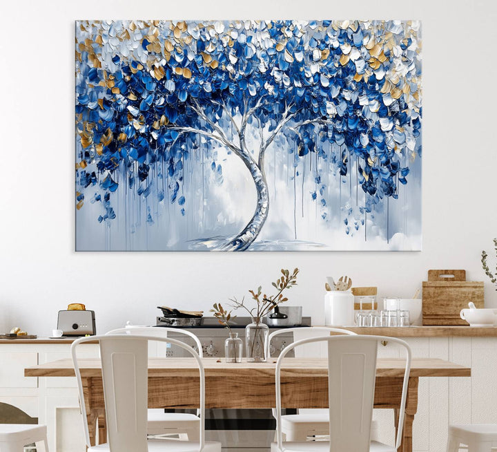 The Blue and Gold Abstract Tree Wall Art showcases a swirl trunk and features blue, silver, and gold leaves on a framed canvas print.