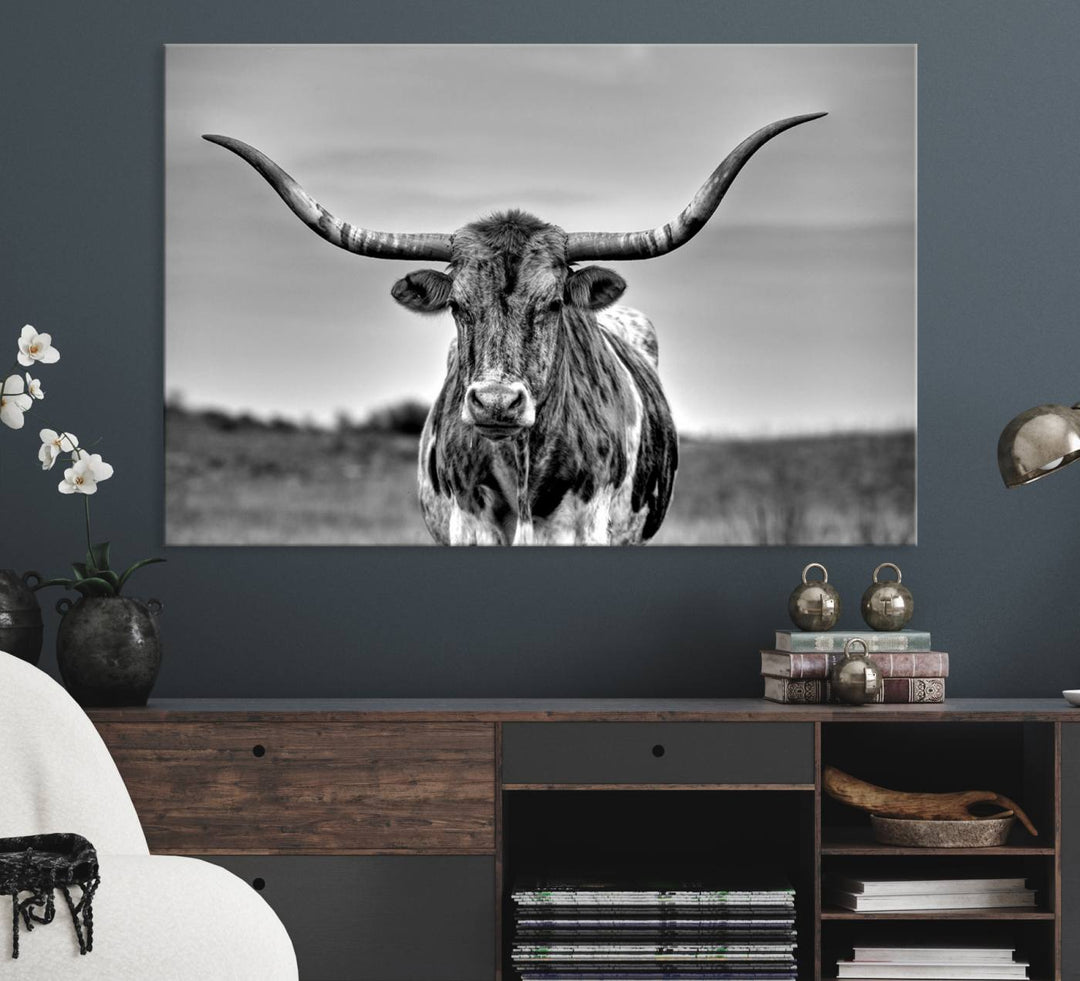 The Texas Longhorn Cow wall art, divided into three panels, is of gallery quality and displayed on a dark wall.