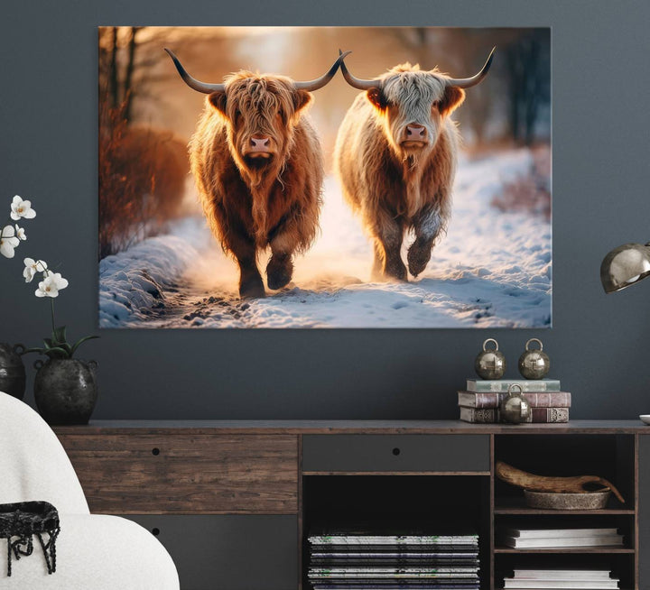 The wall art is a Scottish Highland Cow Horn canvas print featuring cows on a snowy path bathed in warm sunlight, serving as a rustic decor piece.