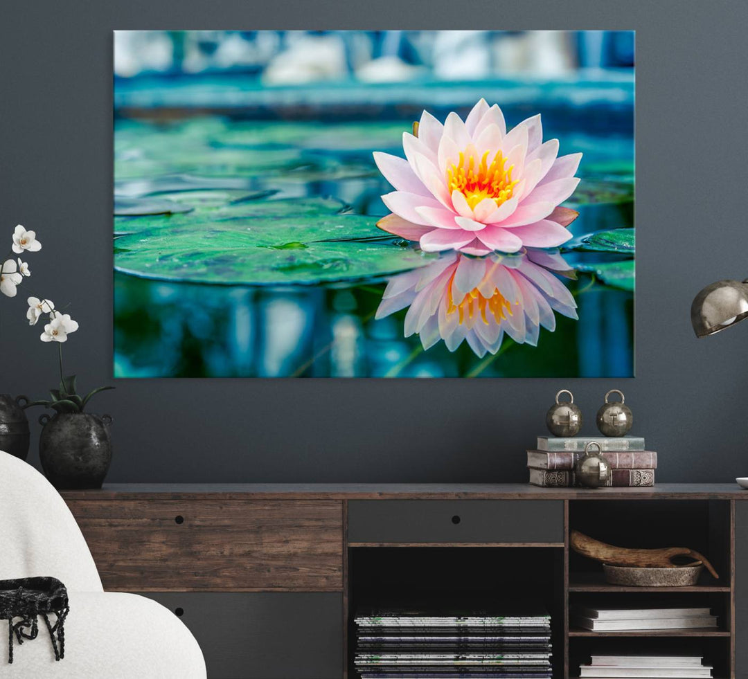 The Lotus Flower Canvas Print showcases a pink water lily with a yellow center gracefully floating on a calm pond.