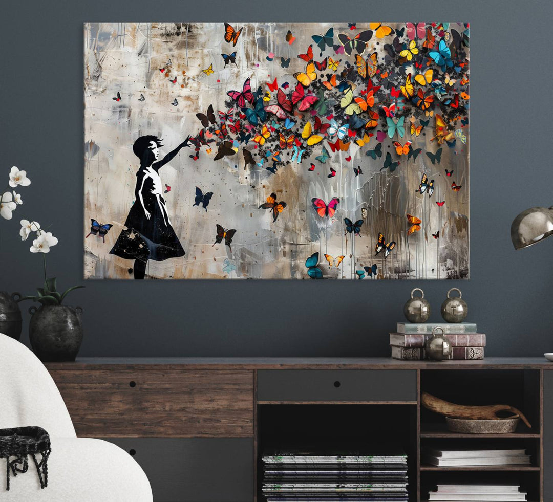 The Banksy Butterfly Girl 3-Piece Modern Graffiti Canvas Wall Art features a silhouette of a girl reaching for butterflies.