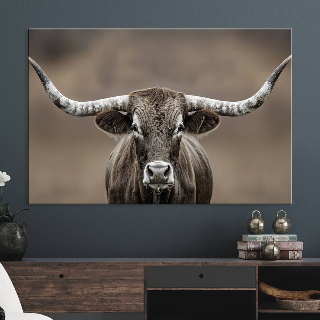 A close-up of a longhorn bull facing forward is featured in the Framed Texas Test-1, set against a blurred brown background.