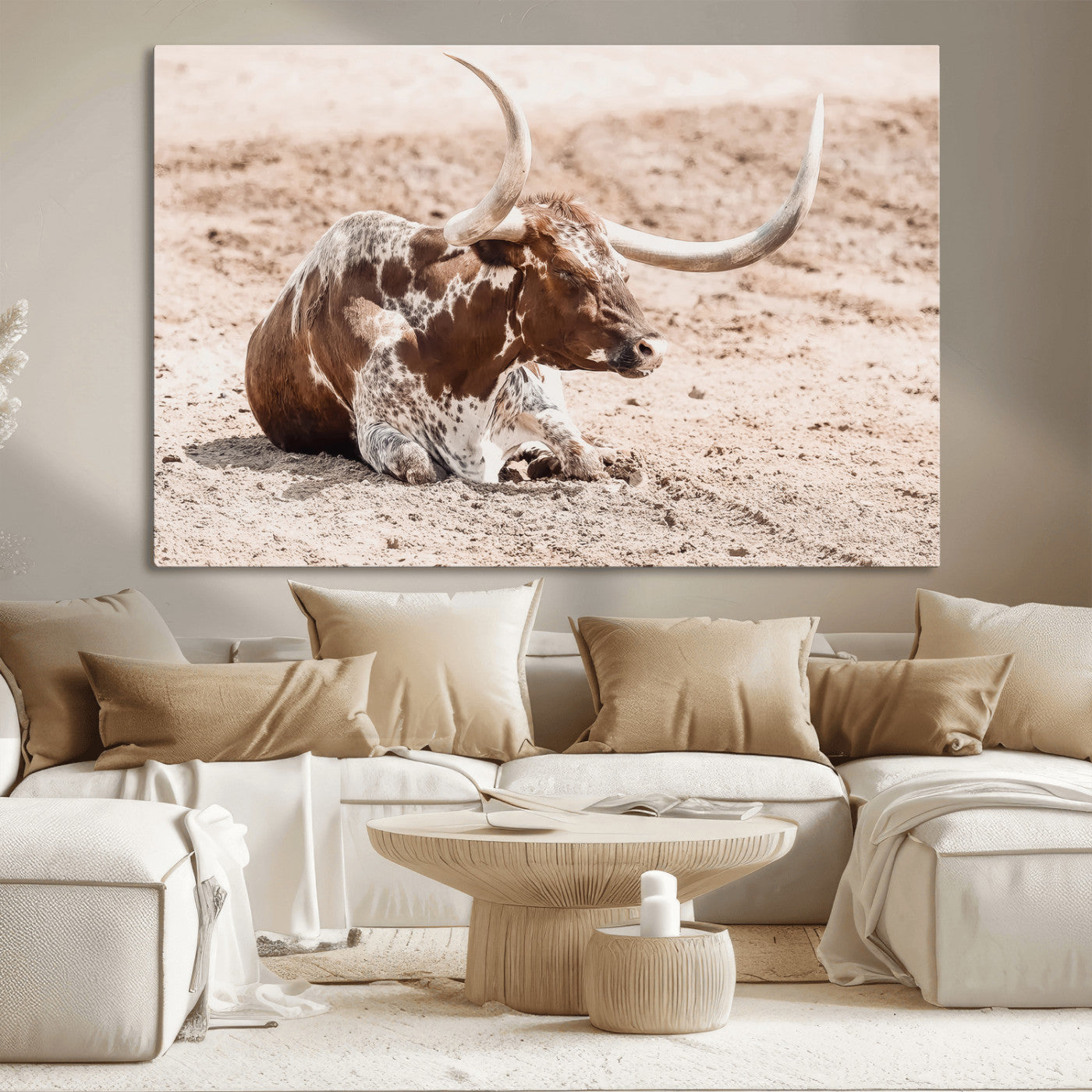 Texas Longhorn bull resting on dusty ground with warm tones, ideal for rustic western or farmhouse-themed wall decor.