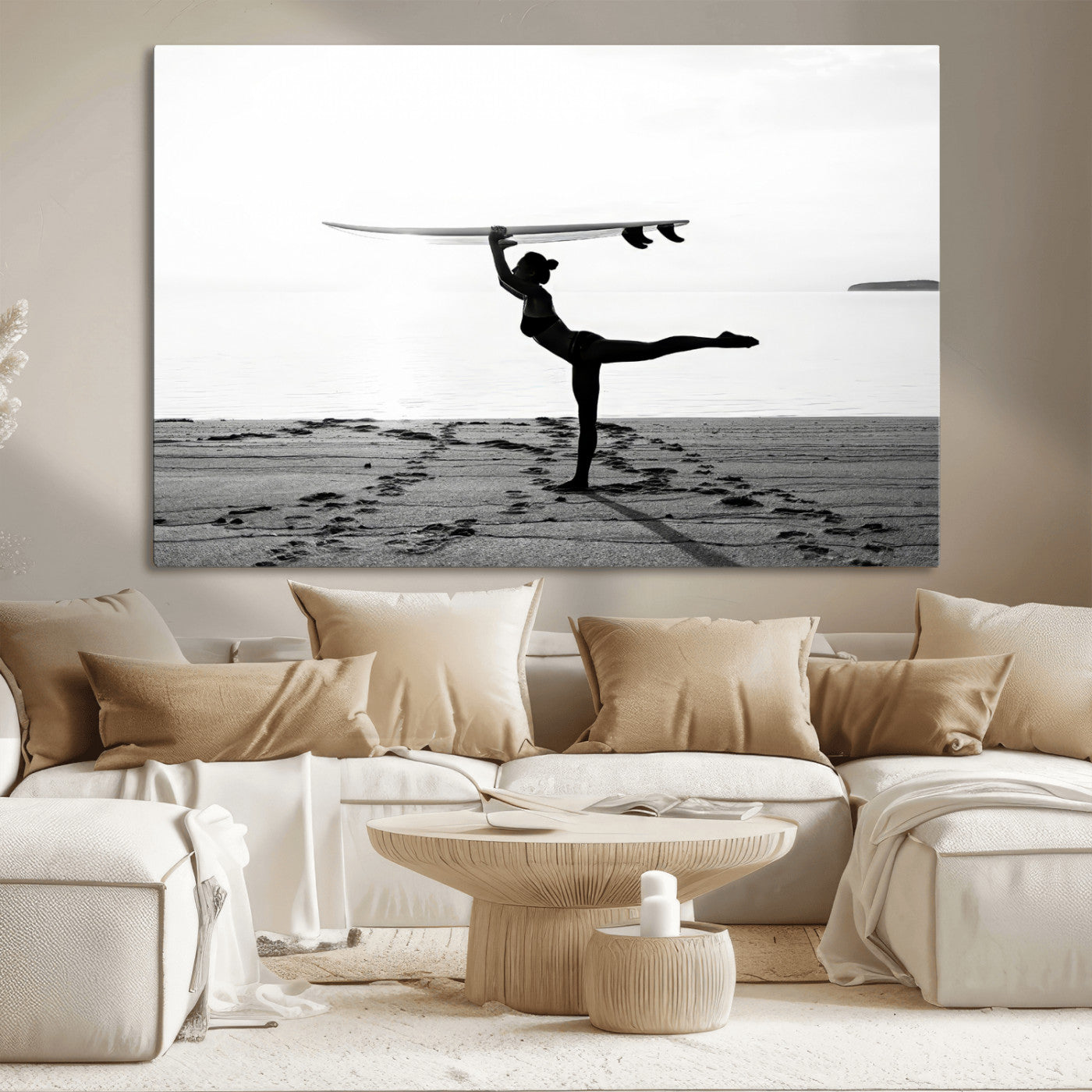 A woman balances a surfboard on her head while striking a yoga pose on the beach, silhouetted against a calm ocean horizon.
