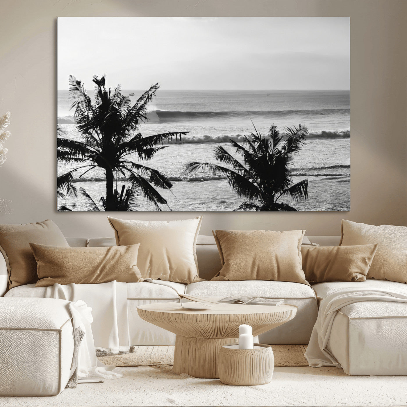 Black and white view of ocean waves crashing on a tropical coastline, framed by silhouetted palm trees under a vast, open sky.