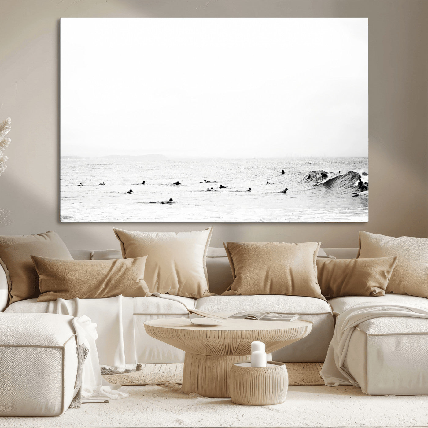A group of surfers floating in the ocean, waiting for waves under a vast, moody sky, captured in black and white.