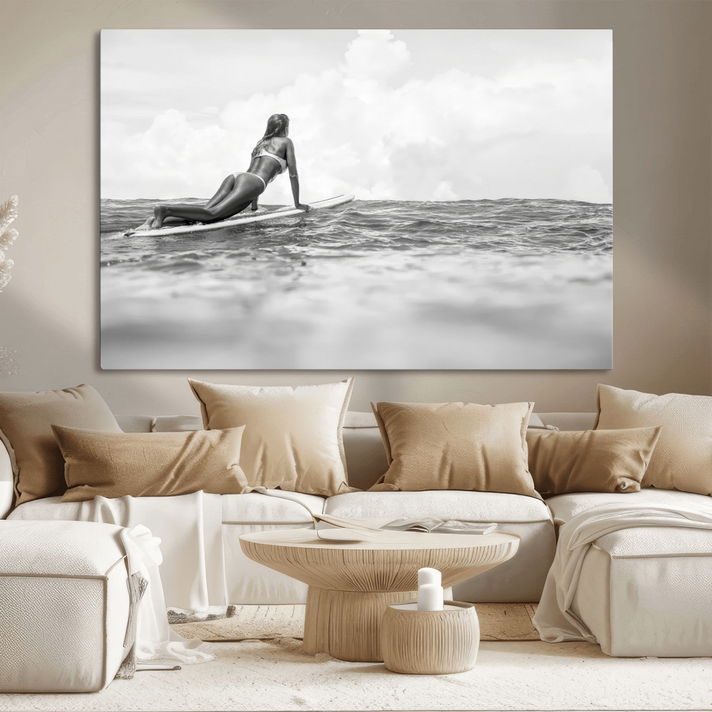 A black and white ocean scene featuring a surfer girl waiting on her board, gazing at the horizon, capturing a tranquil and adventurous coastal moment.