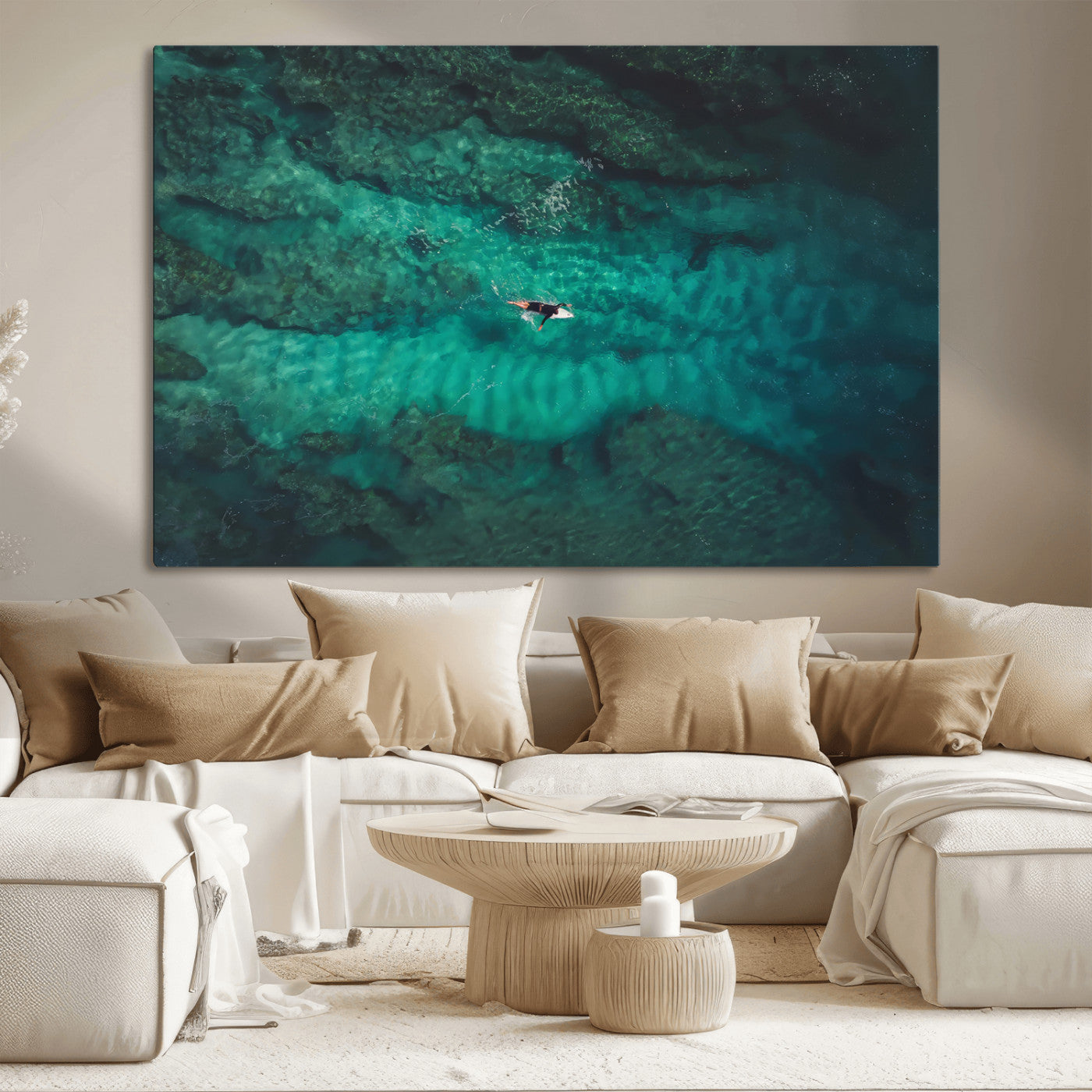 An aerial view of a solo surfer paddling through crystal-clear turquoise waters over a sunlit reef, capturing the beauty and serenity of open water surfing.