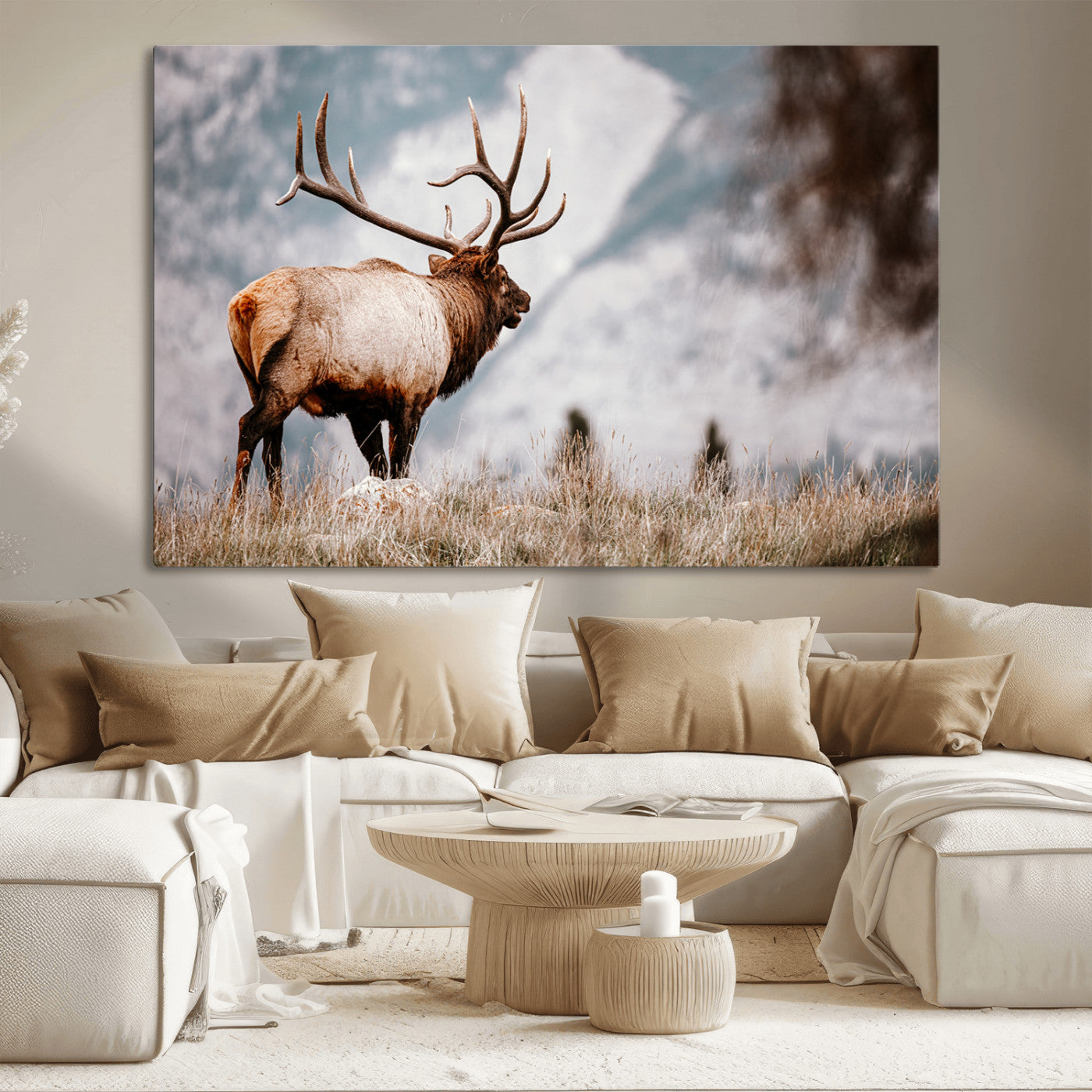 Majestic elk with large antlers standing in grass with snowy mountains in background, perfect for rustic cabin or lodge style decor.
