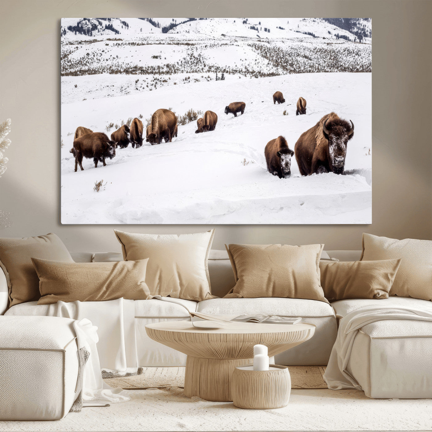 A herd of bison walking through deep snow in a mountain valley, perfect for rustic, cabin or western-themed wall decor.