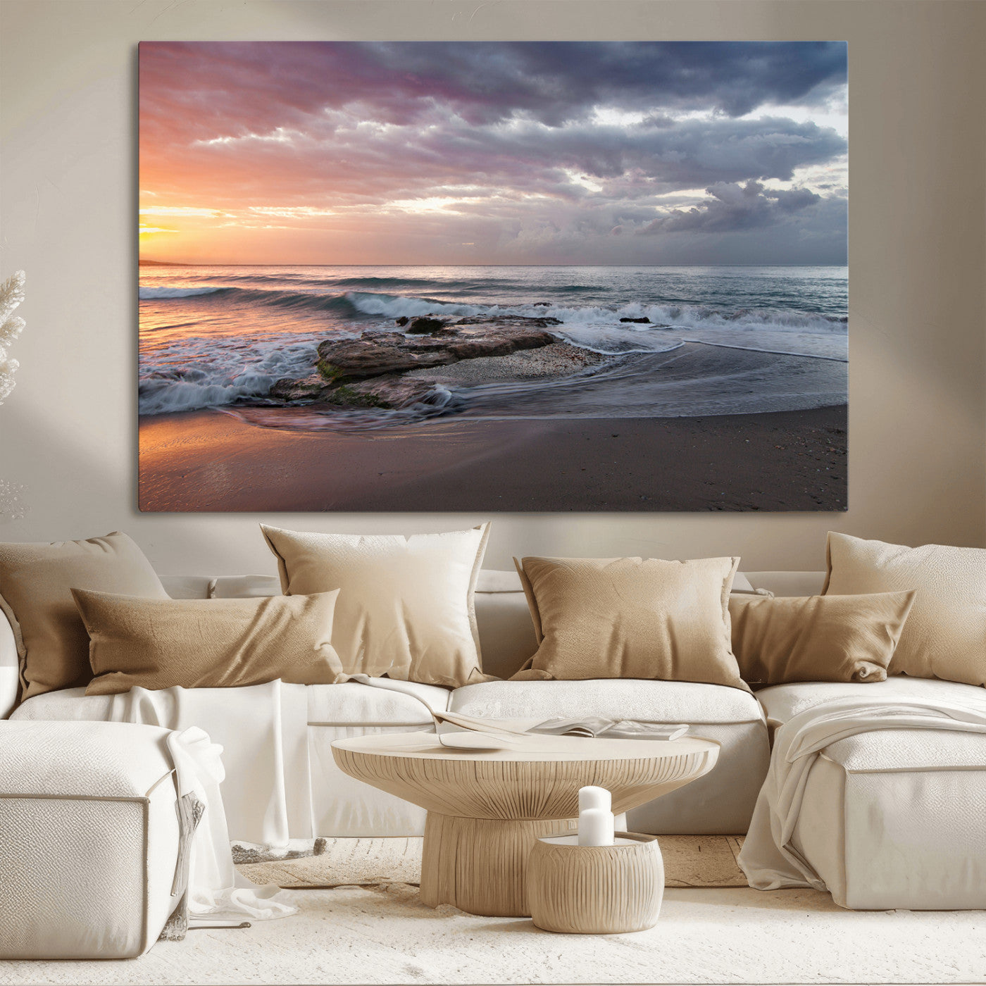 Dramatic sunset over a rocky shoreline with ocean waves gently reaching the sandy beach, creating a serene and coastal atmosphere.
