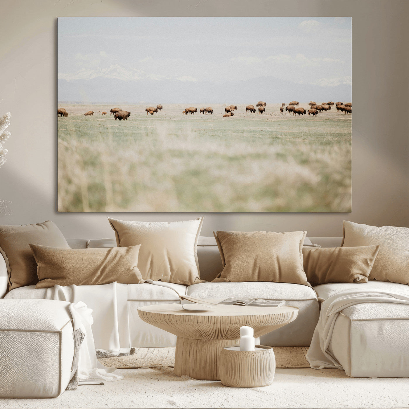 A herd of bison grazing in an open prairie with distant mountains under a soft sky, creating a serene and rustic Western landscape.