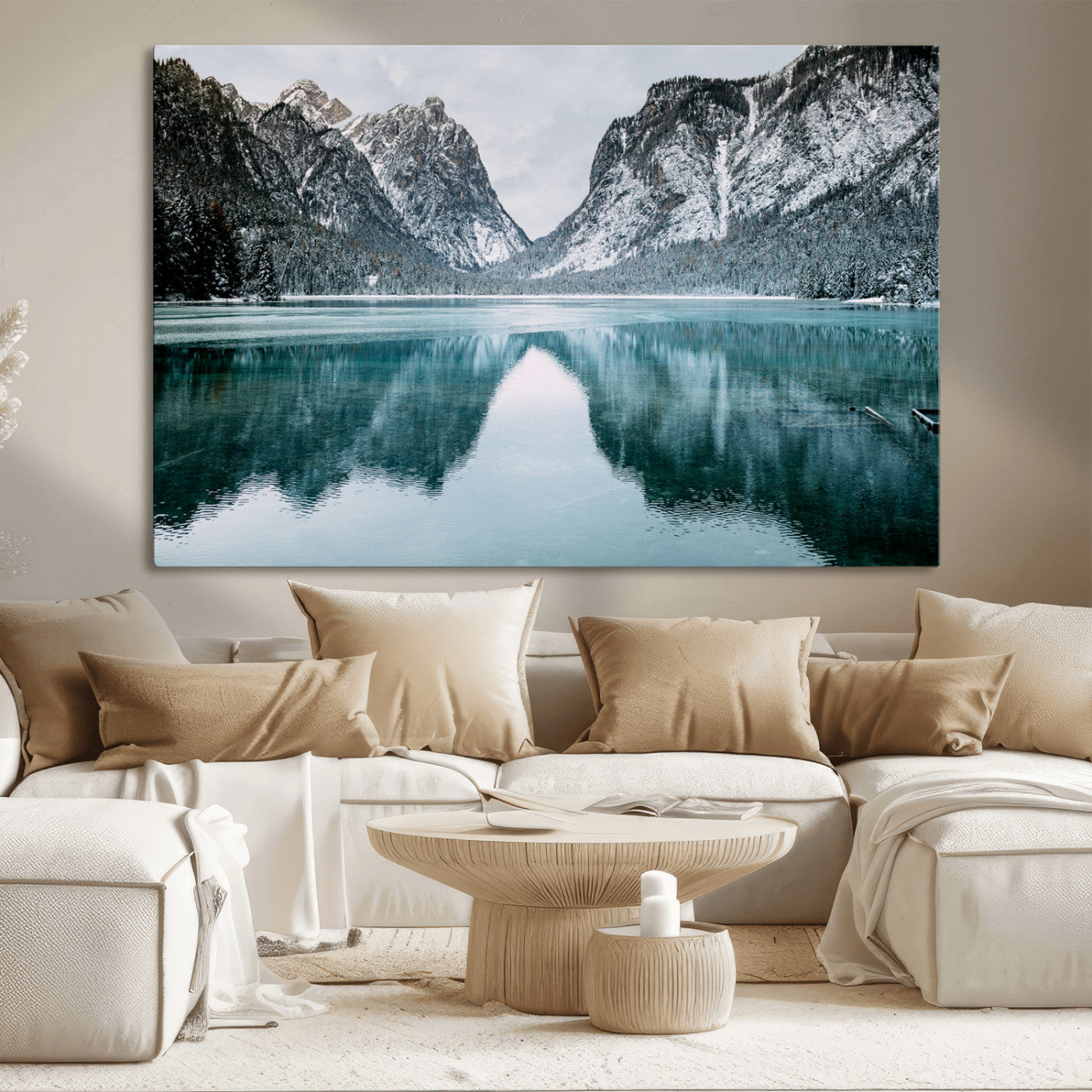 Crystal-clear alpine lake reflecting snow-covered mountains, surrounded by evergreen trees, creating a serene and tranquil winter landscape.