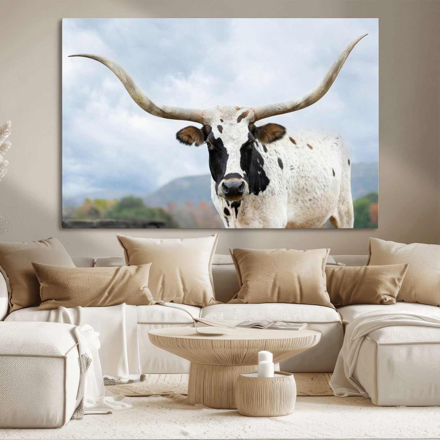 Close-up of a Texas Longhorn with curved horns, black and white markings, set against a cloudy sky and distant hills, perfect for rustic decor.