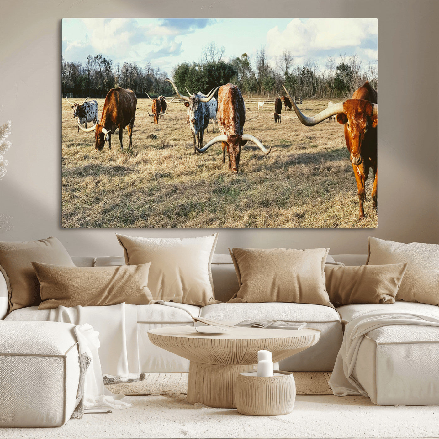 A herd of Texas Longhorn cattle grazing in an open field under a partly cloudy sky, capturing a rustic and Western ranch aesthetic.