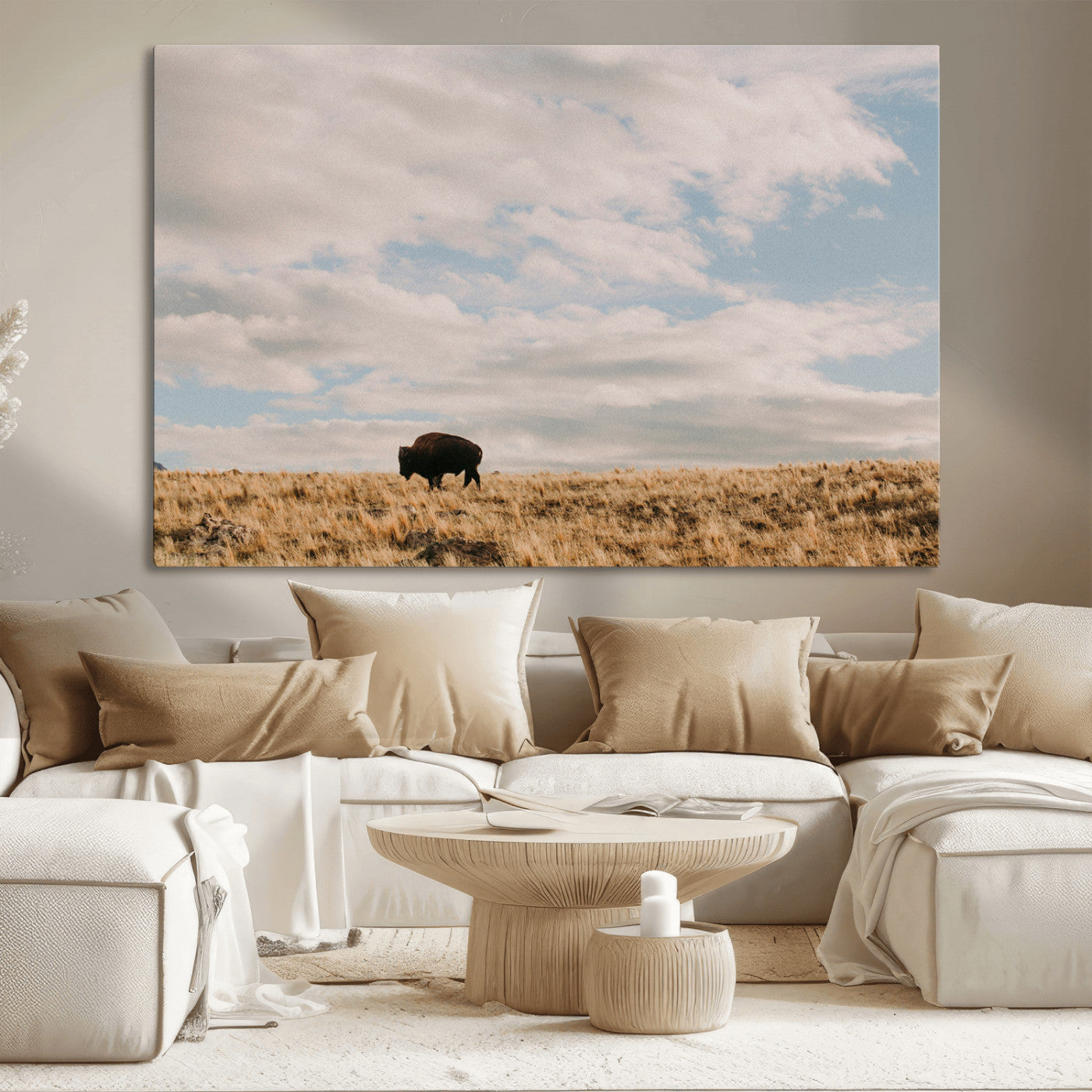 A solitary bison walking across a golden prairie under a vast, cloud-filled sky, evoking a peaceful, rustic western landscape for home decor.