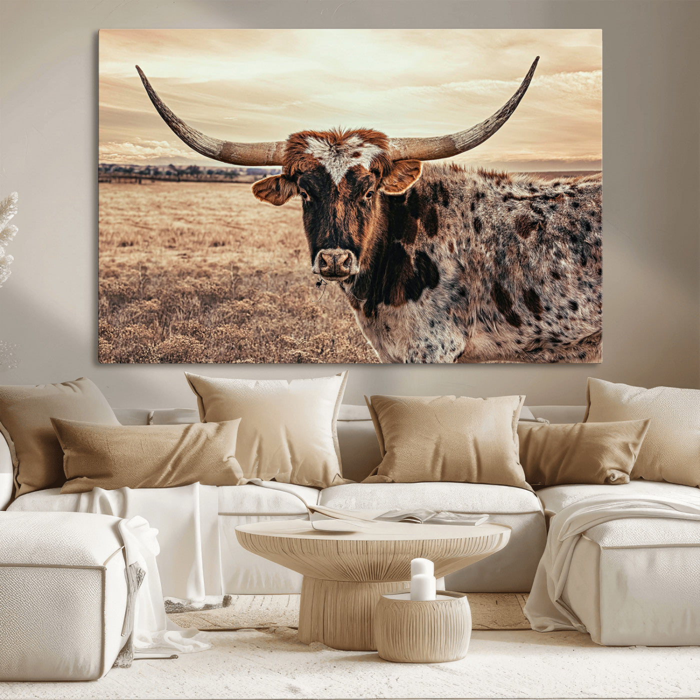 Close-up of a longhorn cow with distinctive curved horns standing in a dry grass field under a cloudy sky.