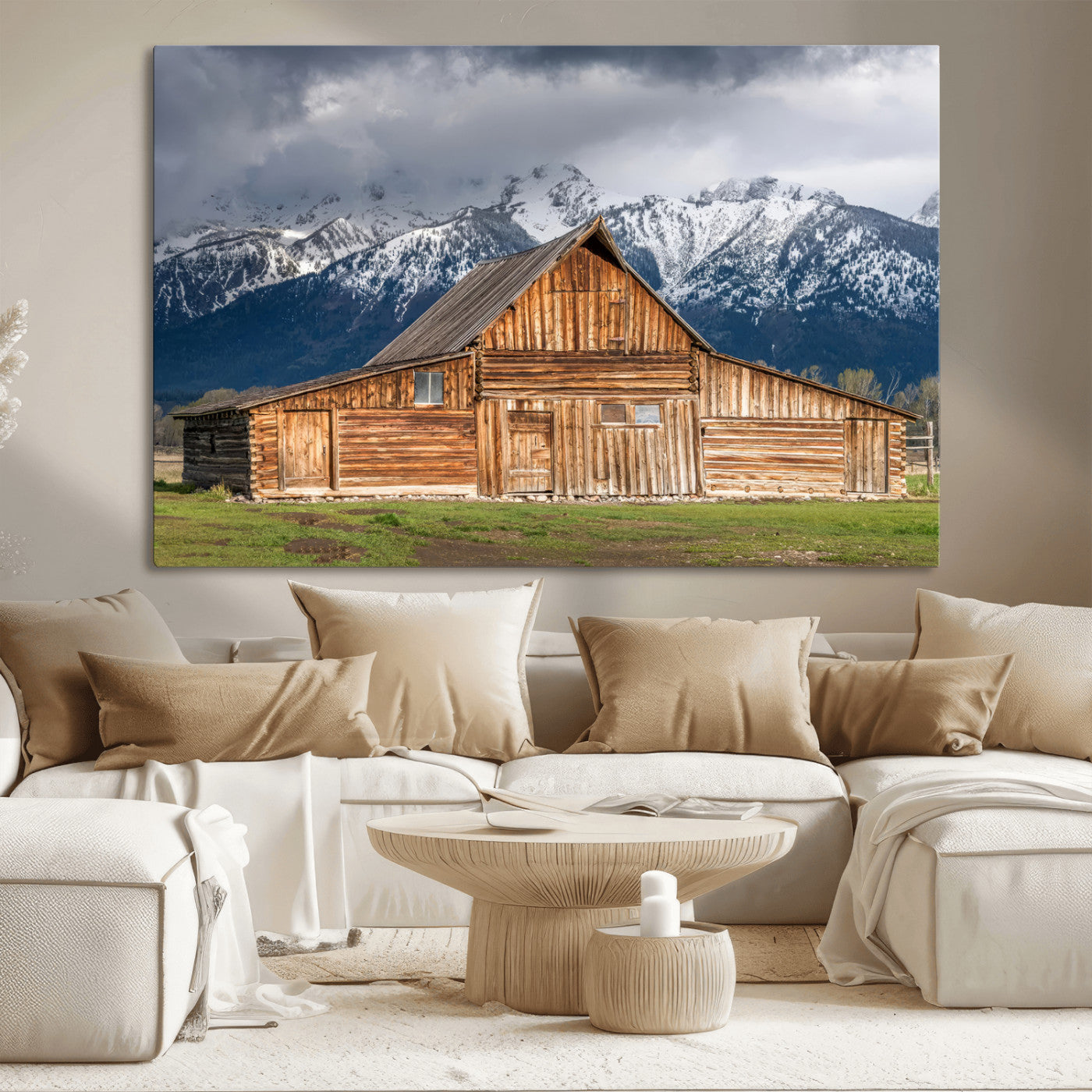 A stunning wall art canvas print featuring a rustic wooden barn set against a backdrop of snow-capped mountains under a dramatic cloudy sky, perfect for adding a touch of rural charm to any space.