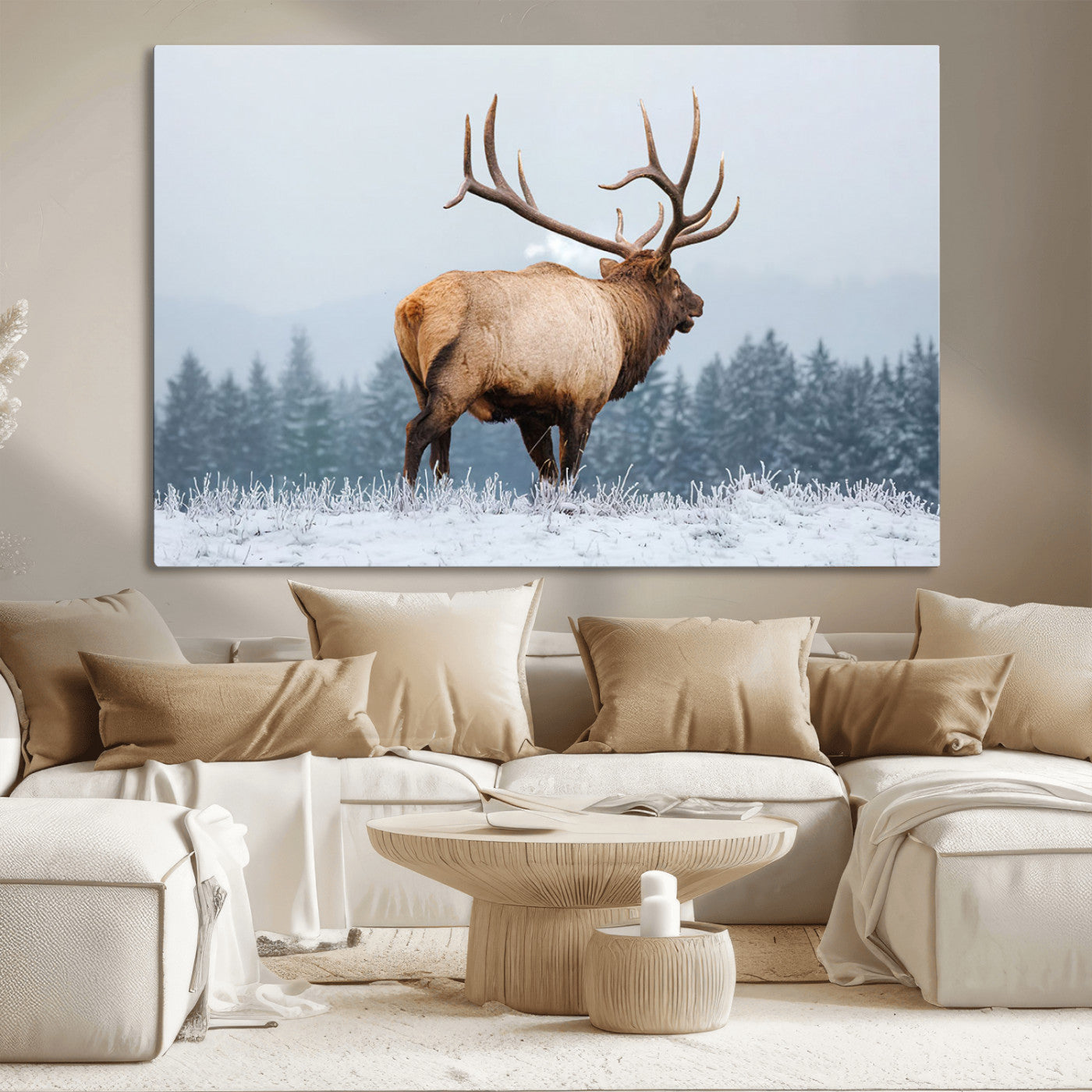 A majestic elk standing in a snowy landscape, with large antlers, set against a backdrop of evergreen trees and a soft winter sky.