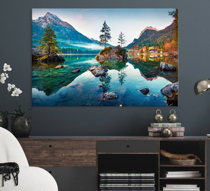 The 3-panel wall art showcases a serene mountain lake with rocky islands and trees, creating an ideal focal point for dining rooms or offices.