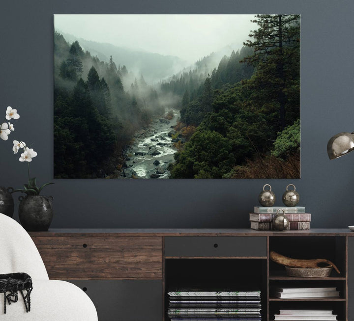 The Misty Forest Wall Art features a serene landscape with a misty river and evergreens, ideal for enhancing the ambiance of any living room or cabin.