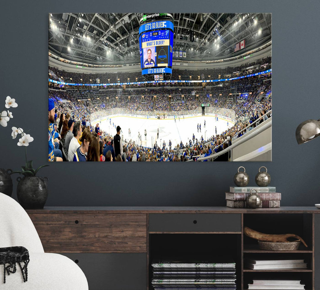 Wall art prints depicting the bustling scenes of the St. Louis Blues being cheered on by a full house at the Enterprise Center, beneath a large scoreboard.