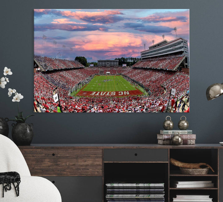 The wall art captures an NC State Wolfpack game under a vibrant sunset on triple canvas.