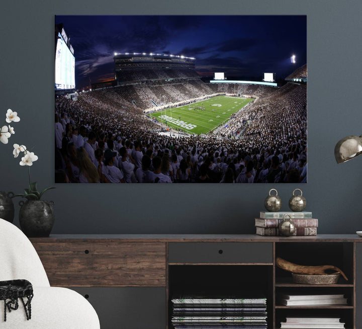 A packed football stadium at night, with bright lights and fans in white, depicted in a Michigan State Spartans Stadium wall art.