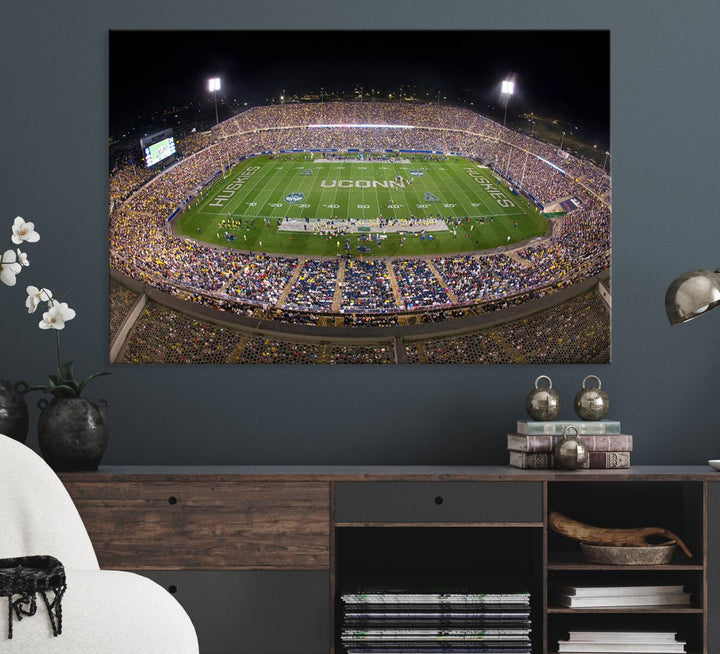 A large football stadium at night, featuring the UCONN Huskies, is depicted on the East Hartford Pratt & Whitney Stadium Wall Art Canvas Print.