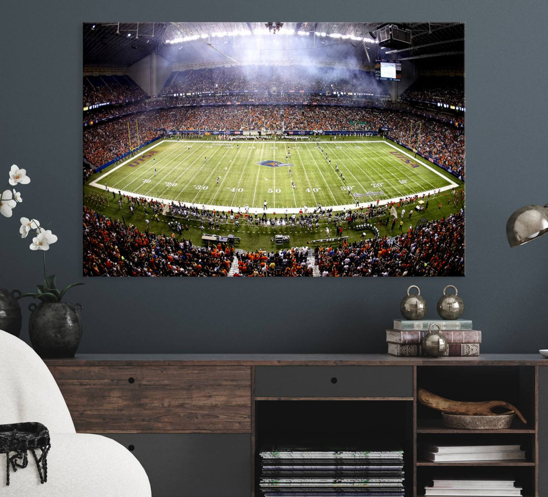 The modern living room features an Alamodome wall art canvas print, depicting a stadium filled with spectators for a UTSA Roadrunners game.