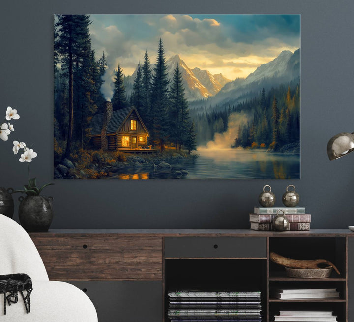 Serene sunset lake wall art: a cozy mountain cabin with lights, framed by pine trees and set against a moody sky. Ideal for adding rustic lodge charm to your space.