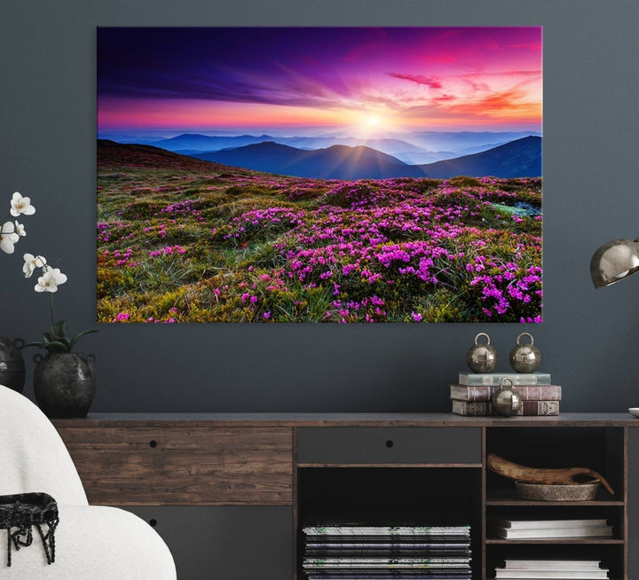 A 3-panel landscape photography canvas of a sunset over mountain meadows with purple wildflowers decorates the wall.