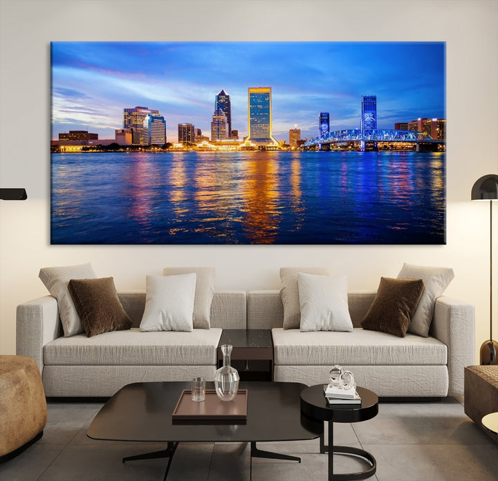 A cozy living room features the Jacksonville Wall Art Canvas Print, a large triptych crafted on museum-quality canvas that beautifully depicts the Jacksonville city skyline at sunset.