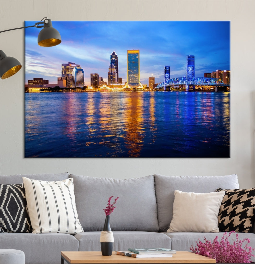 A cozy living room features the Jacksonville Wall Art Canvas Print, a large triptych crafted on museum-quality canvas that beautifully depicts the Jacksonville city skyline at sunset.