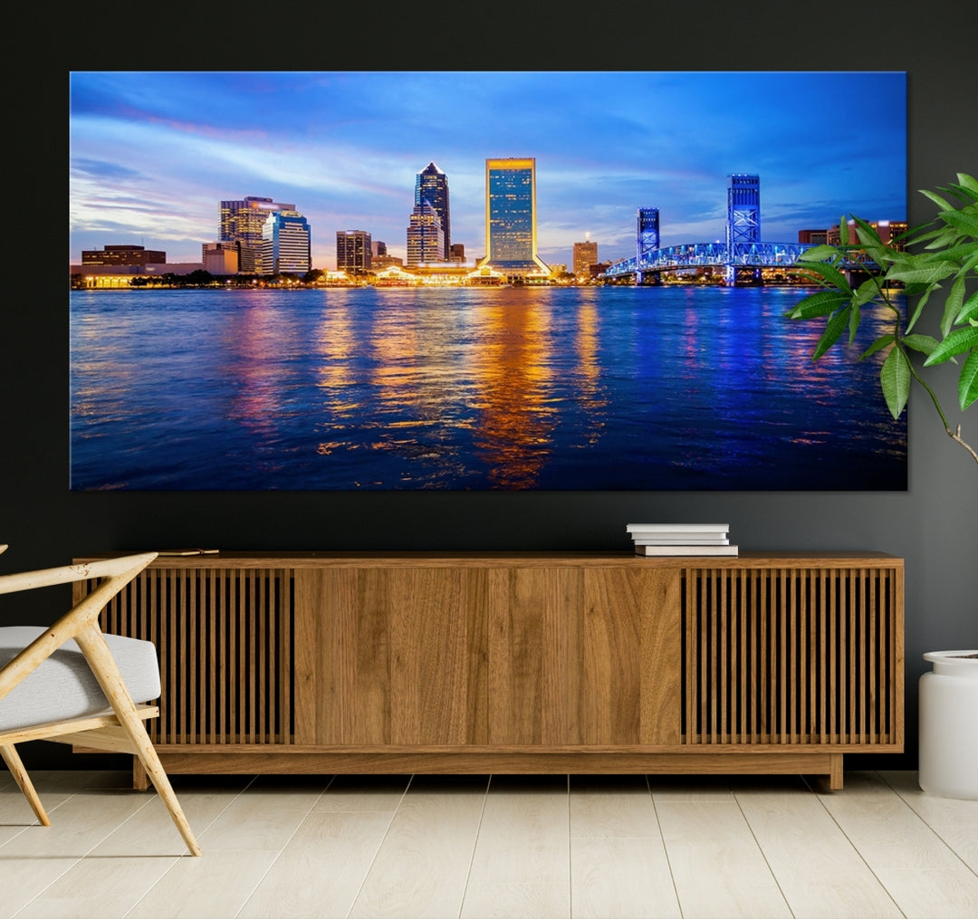 A cozy living room features the Jacksonville Wall Art Canvas Print, a large triptych crafted on museum-quality canvas that beautifully depicts the Jacksonville city skyline at sunset.