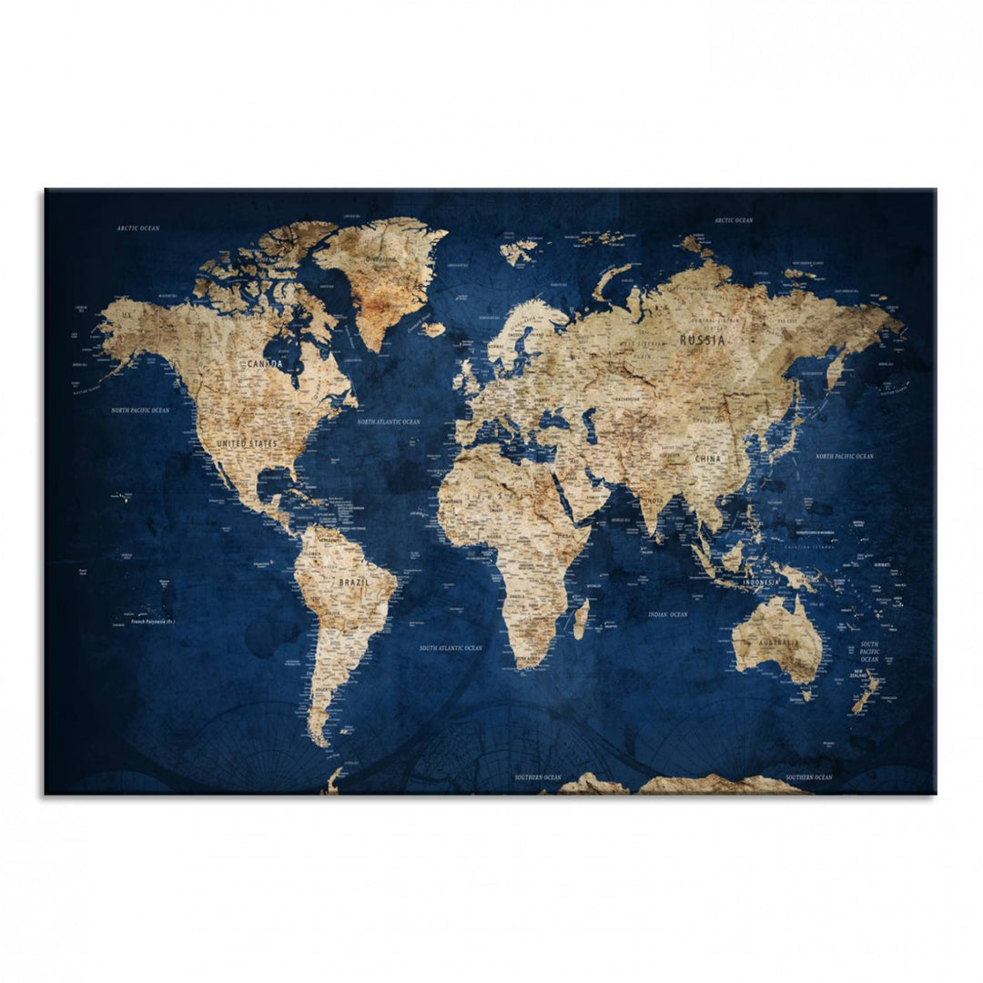 A large framed world map canvas print features beige landmasses set against a grunge-stained deep blue ocean background, creating an intriguing piece of wall art.