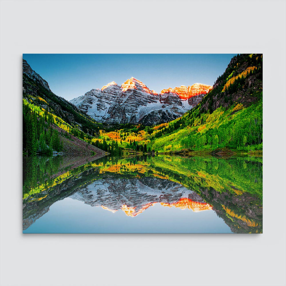 The Sunrise Maroon Bells Lake Wall Art Print beautifully captures North Maroon Peak mirrored in the tranquil lake, framed by lush greenery.