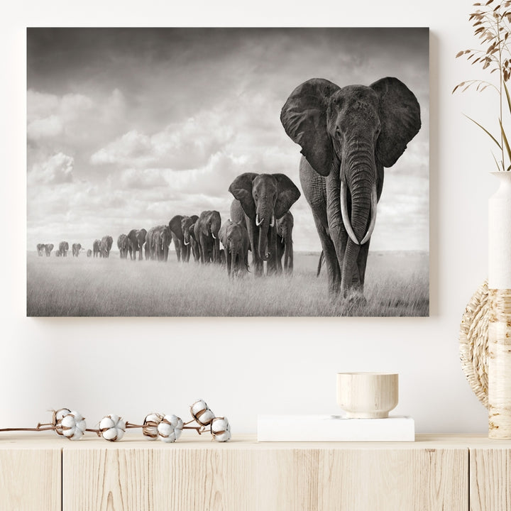 The "Herd of Elephants Wall Art Canvas Print" features an elegant black and white triptych of elephants walking in a line, beautifully displayed on museum-quality canvas with a UV-protective coating. This artwork arrives ready to hang and adds sophistication to any space.