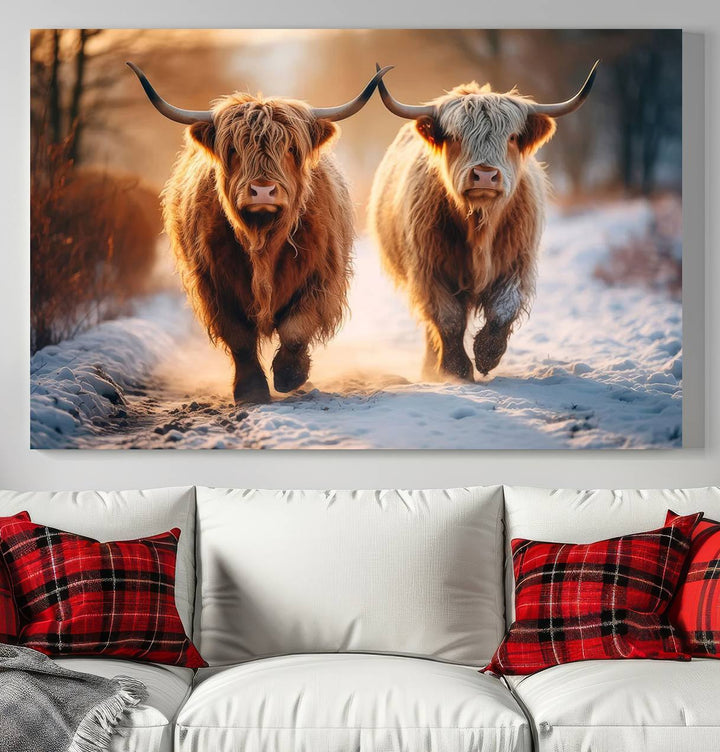 The wall art is a Scottish Highland Cow Horn canvas print featuring cows on a snowy path bathed in warm sunlight, serving as a rustic decor piece.