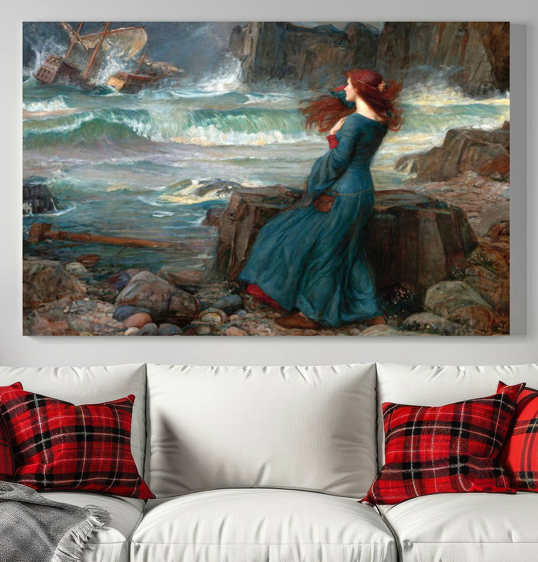 The Miranda by the Shore Wall Art Canvas Print depicts a woman in a blue dress standing by the sea, watching a shipwreck.