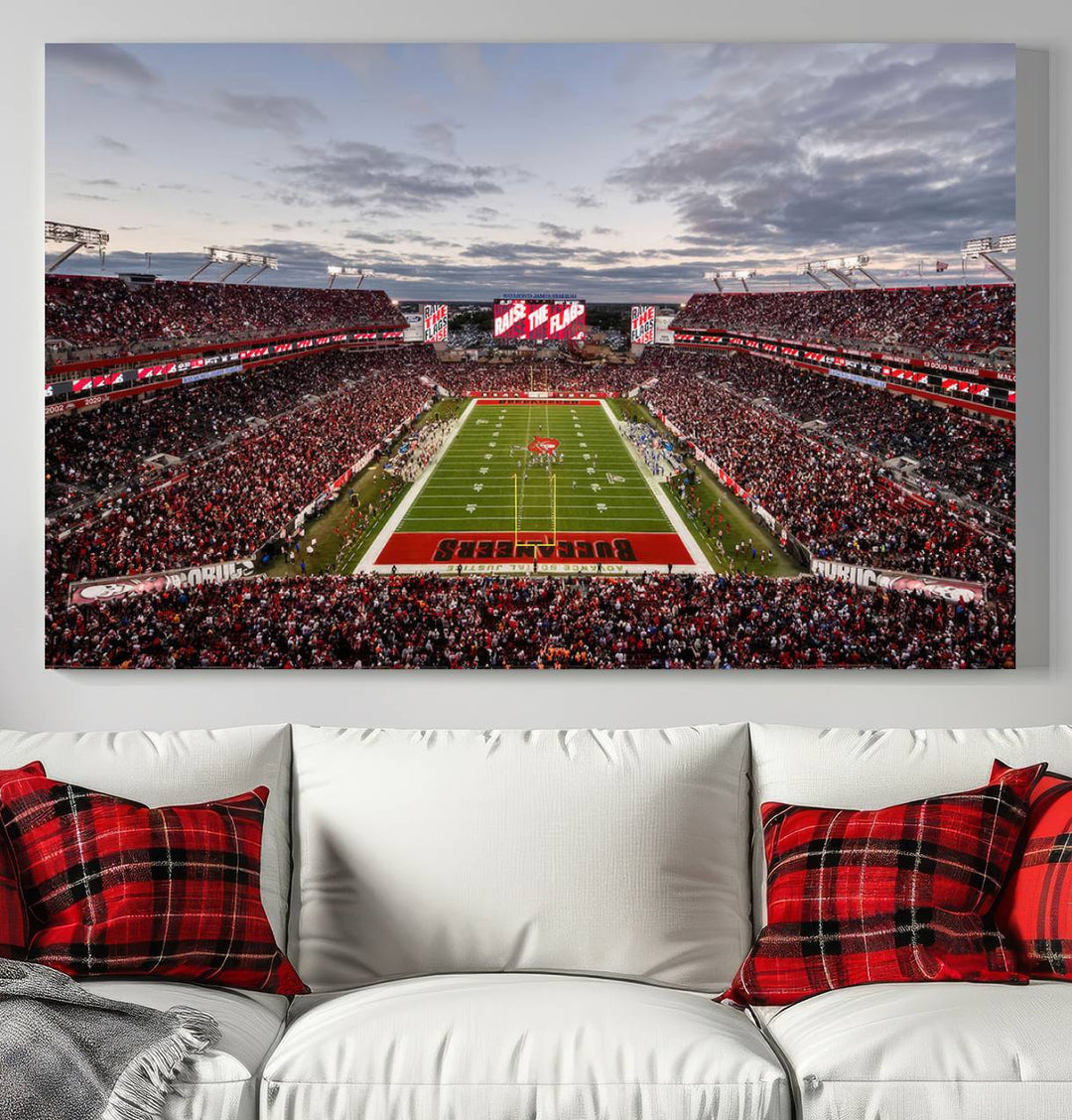 The wall art captures a stunning scene of Raymond James Stadium bathed in the warm hues of sunset. The sky, filled with clouds, provides a dramatic contrast to the vibrant lighting on the field, encapsulating the dynamic energy of a football game.