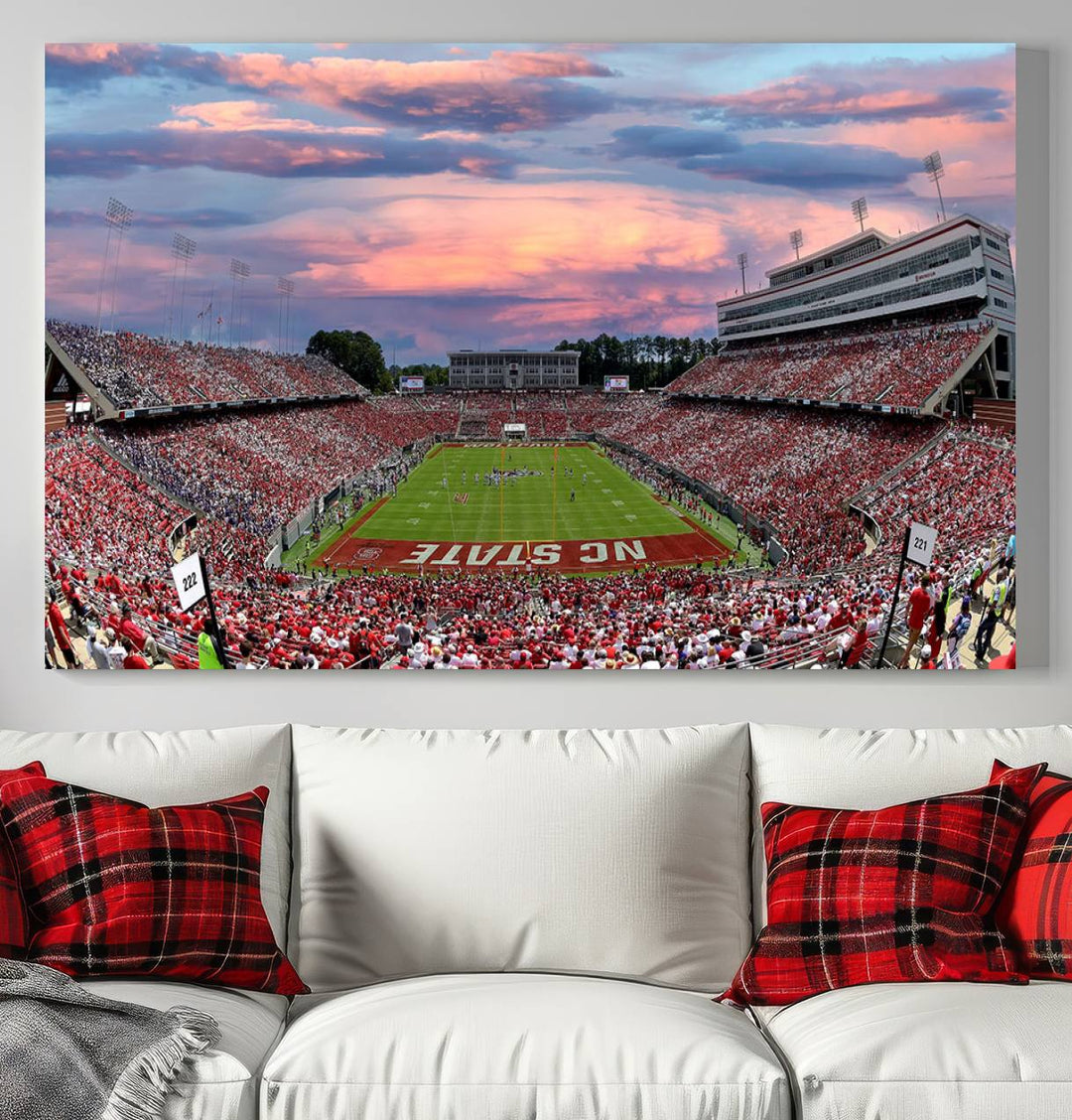 The wall art captures an NC State Wolfpack game under a vibrant sunset on triple canvas.