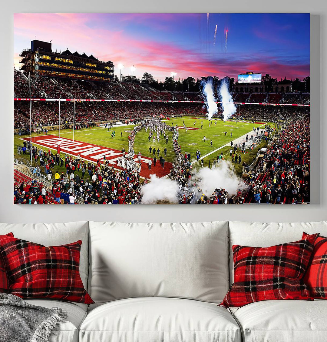 The wall art features a canvas print of the Stanford Cardinal football team, capturing players, fireworks, and smoke against the backdrop of a sunset at Stanford Stadium.