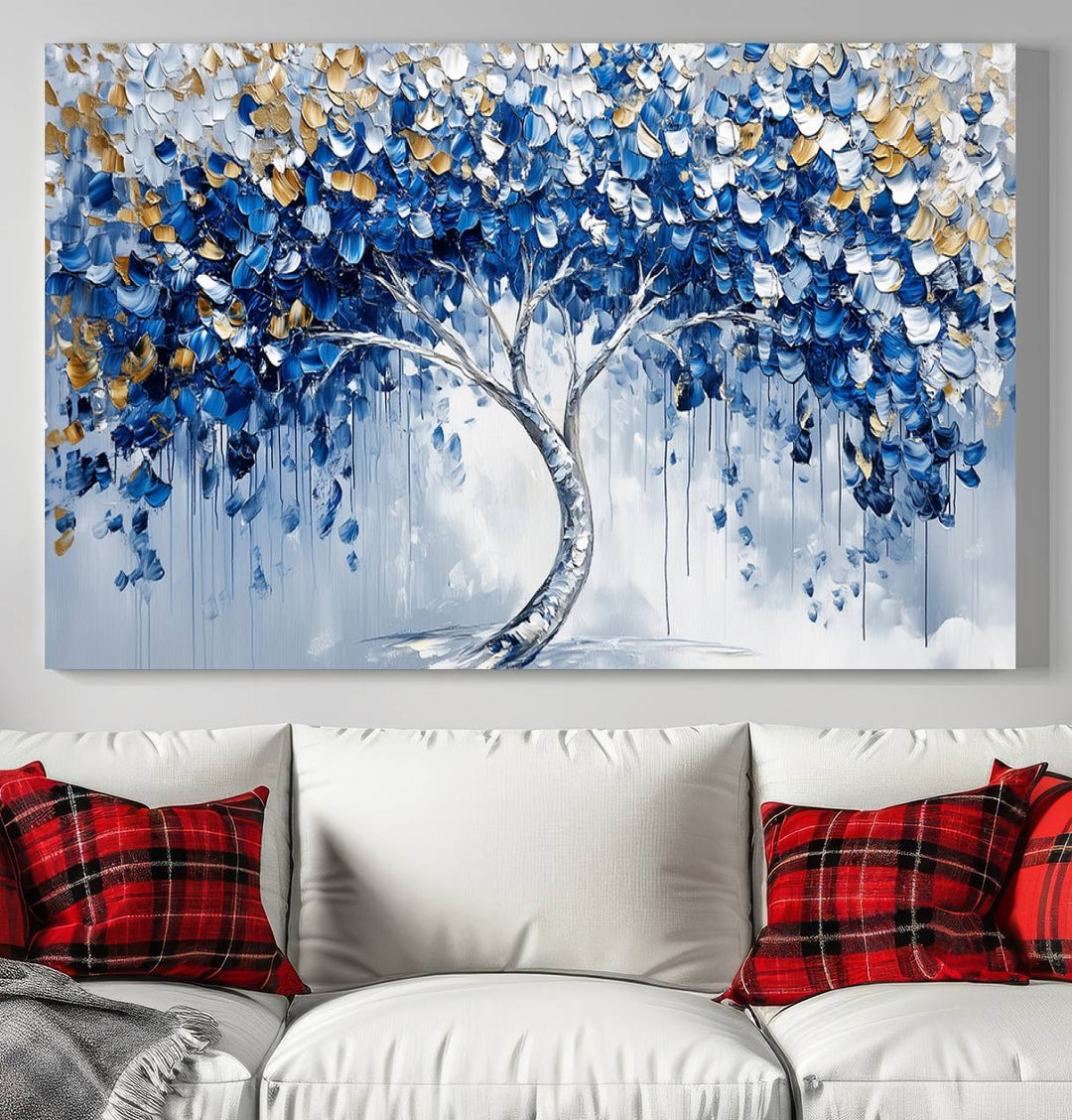 The Blue and Gold Abstract Tree Wall Art showcases a swirl trunk and features blue, silver, and gold leaves on a framed canvas print.