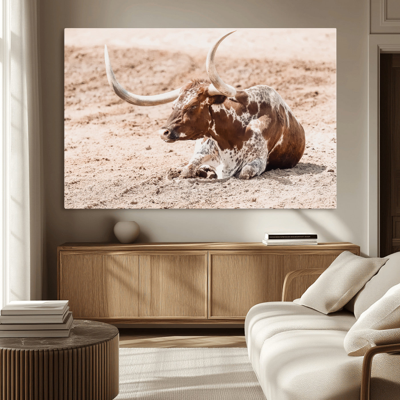Texas Longhorn bull resting on dusty ground with warm tones, ideal for rustic western or farmhouse-themed wall decor.