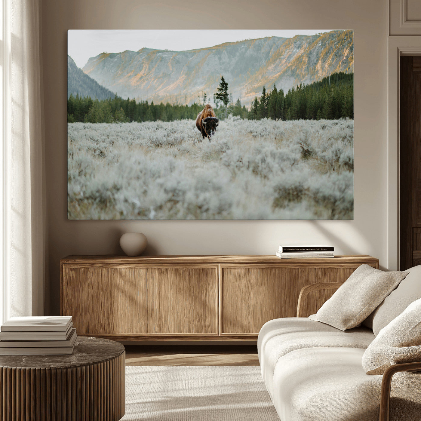 Lone bison standing in a frosted sagebrush field with a pine forest and rugged mountain range in the background under soft morning light – Wall Art Canvas Print.