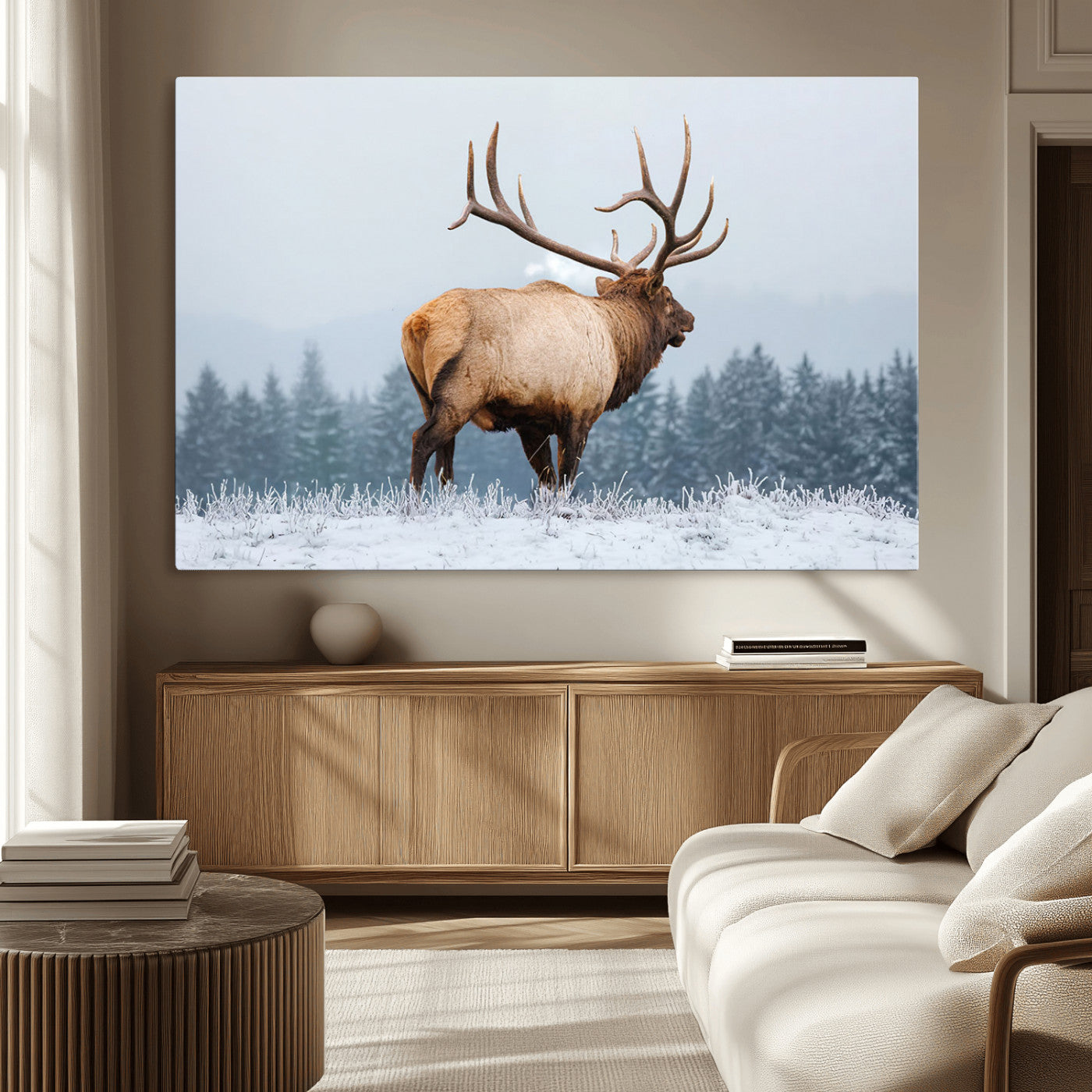 A majestic elk standing in a snowy landscape, with large antlers, set against a backdrop of evergreen trees and a soft winter sky.