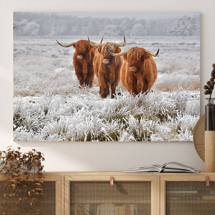 The Highland Cows in Snow canvas showcases three cattle in a frosty field.