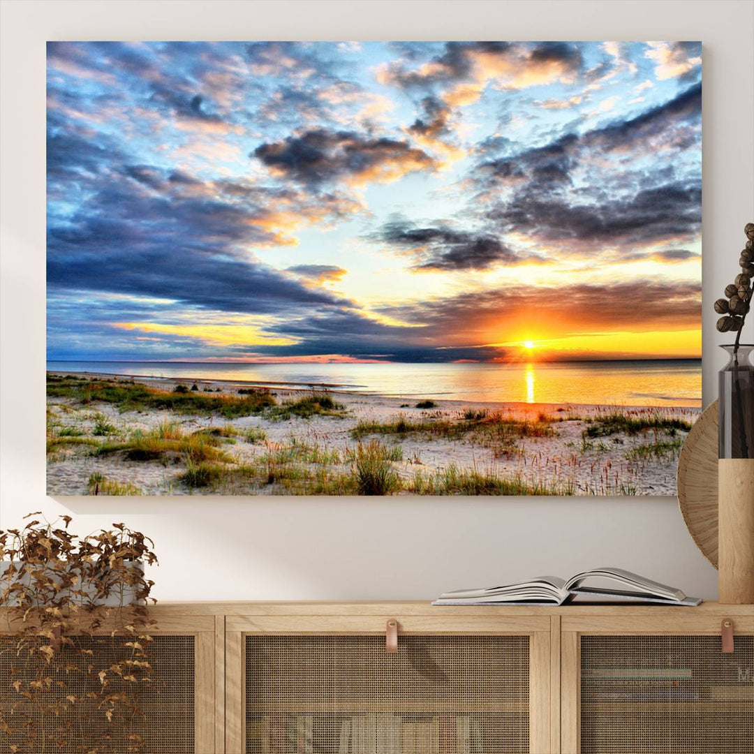 The Sunset On The Ocean canvas wall art features a beautiful beach sunset with grass and clouds.