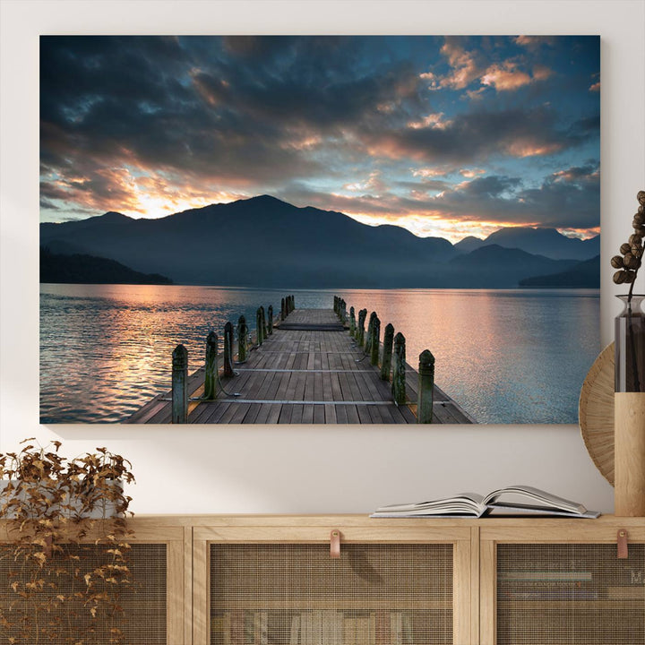 The Mountain Lake Wood Pier Canvas Wall Art depicts a serene lake and mountains, enhancing the beauty of any space.